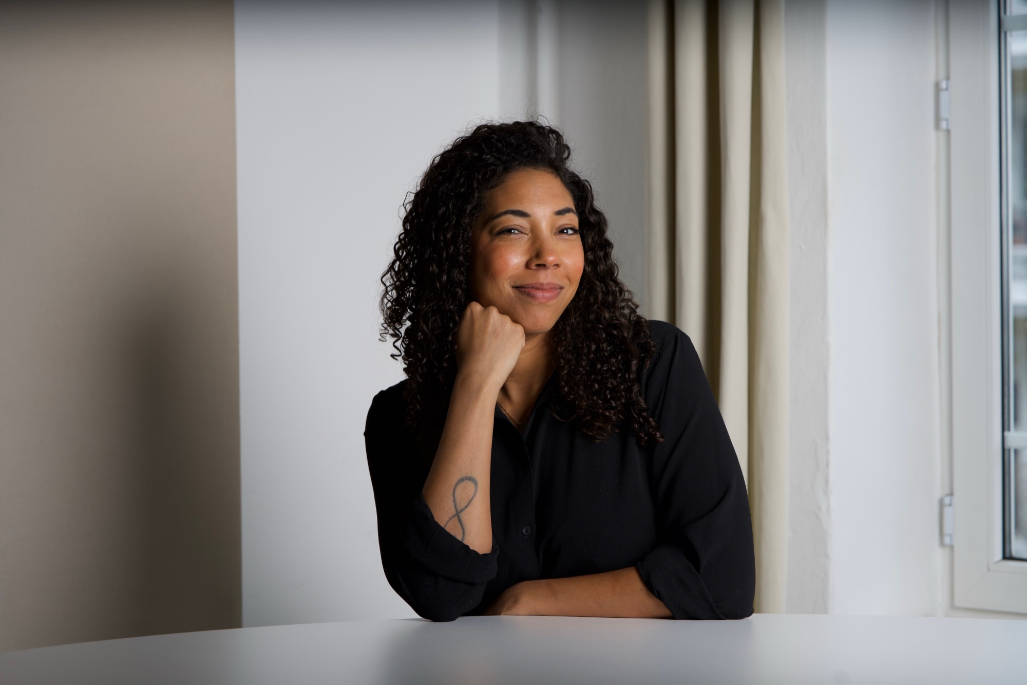 Porträt von Bea Acheampong, Gründerin von ProtoPanda, lächelnd am Tisch